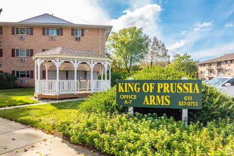 White gazebo on the lawn beside the King of Prussia Arms Apartments property sign